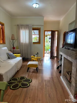 Quarto com cama e piso de madeira clara em um imóvel.
