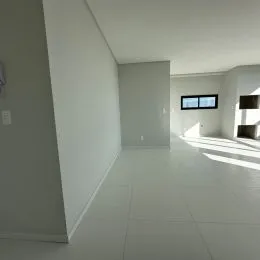 Corredor interno com paredes brancas e piso claro.