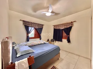 Quarto com cama e cortinas em um imóvel no Brasil.