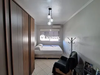 Quarto com cama e armário de madeira em um ambiente interno.