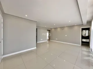 Corredor interno de uma residência com piso claro e paredes cinzas.
