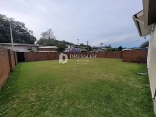 Vista de um quintal gramado com muro de tijolos em Lajeado, Brasil.