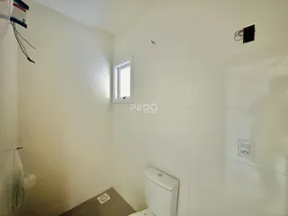 Foto de um interior com paredes brancas e uma janela.