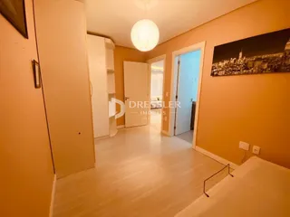 Hall de entrada com piso claro e portas brancas.