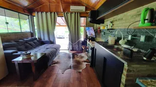 Sala de estar com sofá e área de cozinha em casa em Lajeado.