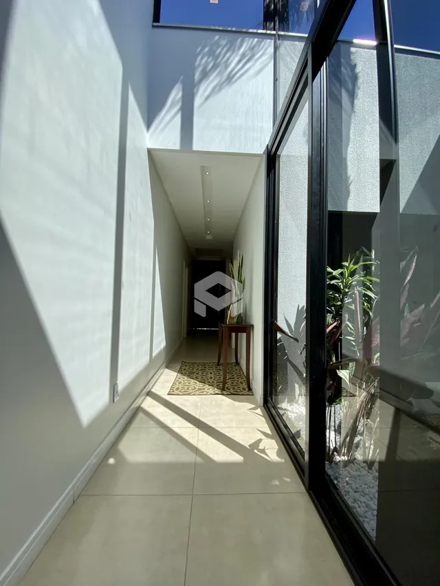 Hall de entrada de uma residência moderna com piso claro e paredes brancas.