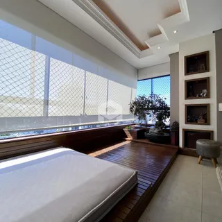 Quarto com grande janela e piso de madeira.