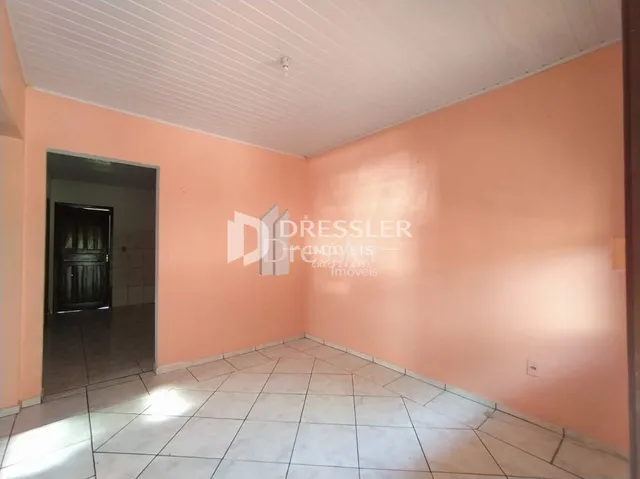Interior de um ambiente com piso de cerâmica e paredes alaranjadas.