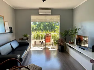 Sala de estar com portas de vidro abrindo para um jardim.