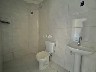 Foto de um banheiro com revestimento cerâmico branco.