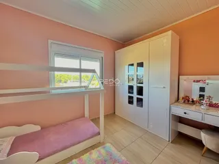 Quarto com cama e armários brancos em um imóvel no Brasil.