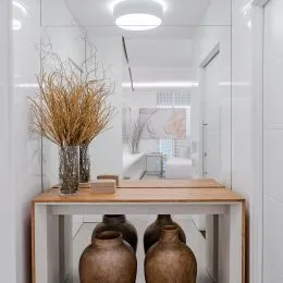 Uma mesa de madeira com vasos escuros está visível na imagem.