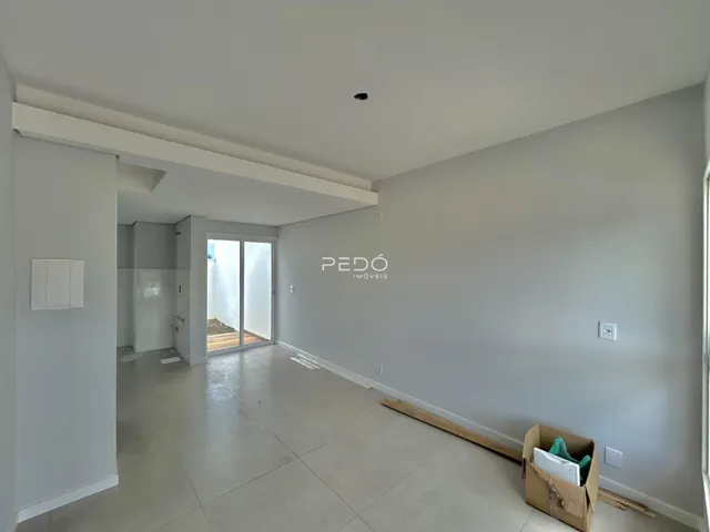 Ambiente interno amplo com piso de cerâmica e paredes claras de uma residência.