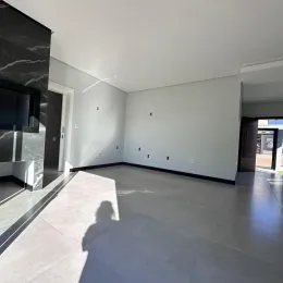 Ambiente interno amplo com piso de concreto e paredes brancas.