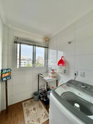 Ambiente interno de uma sala com janela e piso de madeira.