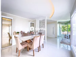 Uma sala de jantar clara com mesa e cadeiras em um imóvel em Lajeado.