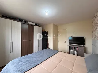 Quarto com armários em madeira e cama.
