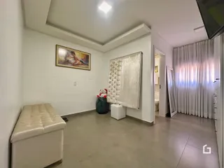 Foto de uma sala de estar interna com paredes brancas e piso de porcelanato.