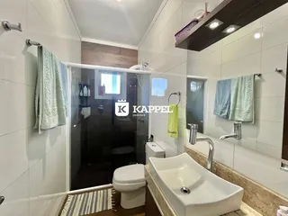 Banheiro com revestimento branco e bancada de mármore.
