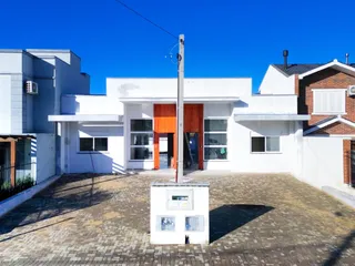 Fachada de uma residência moderna com revestimento branco e entrada de madeira em Lajeado, Brasil.