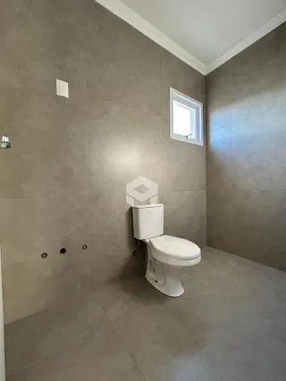 Foto de um banheiro com piso de cerâmica e parede texturizada.