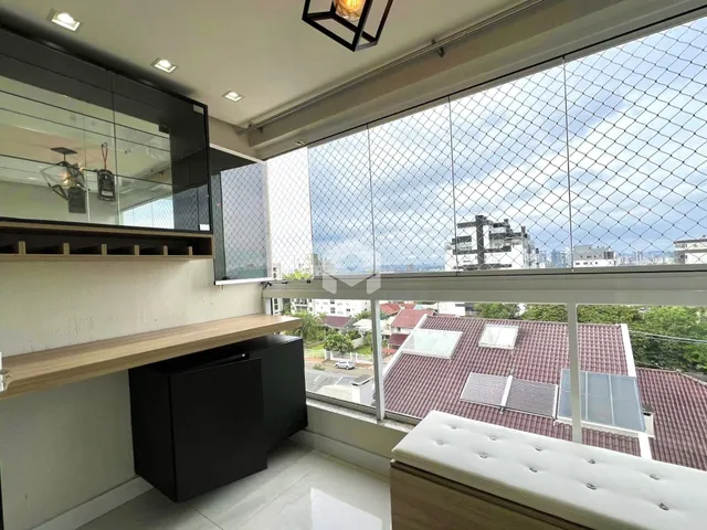 Vista interna de um ambiente com grande janela e vista para telhados.