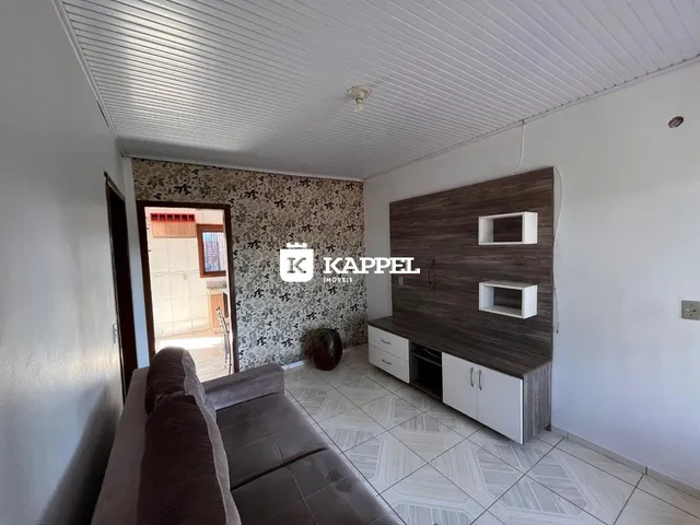 Sala de estar com sofá e painel de madeira na área interna do imóvel.