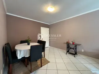 Ambiente interno de uma sala com mesa de jantar e piso de cerâmica.