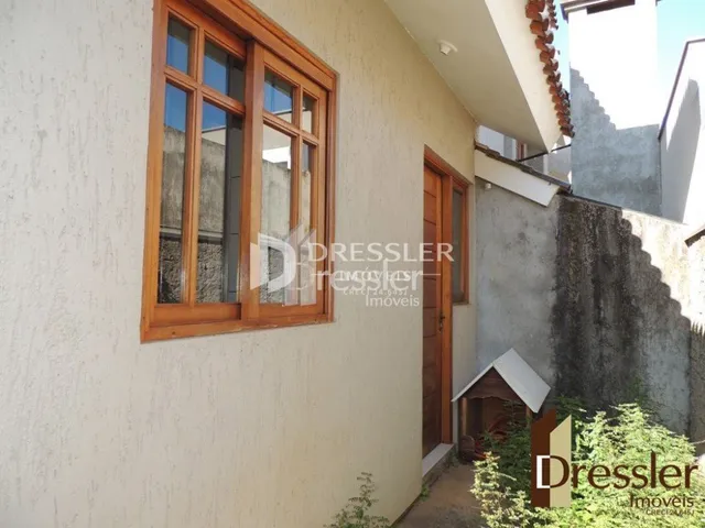 Fachada de uma residência em Lajeado, Brasil, com uma grande janela de madeira.