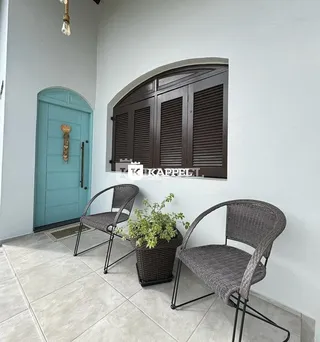Foto da fachada de uma parede externa com portas e janelas de madeira escura.