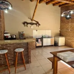 Foto interna de uma cozinha com paredes de tijolo aparente e piso de cerâmica.