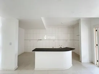 Vista interna de uma cozinha moderna com revestimento branco e ilha central.