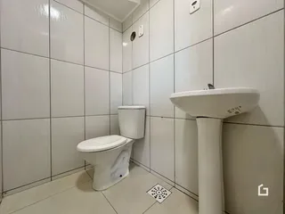 Interior de um banheiro com revestimento cerâmico branco.