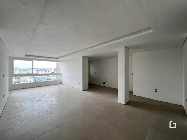 Ambiente interno de uma sala ampla com vista para a paisagem urbana.