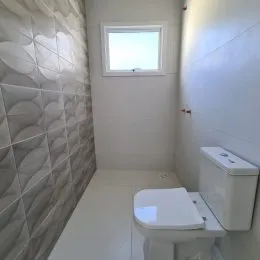 Foto de um banheiro com paredes brancas e um vaso sanitário.