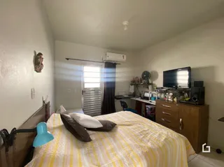 Quarto interno com cama e janela em imóvel no Brasil.