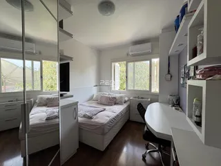 Quarto com duas camas e armários brancos em um imóvel no Brasil.