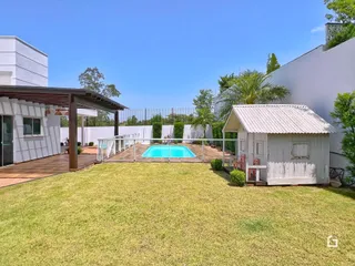 Vista do quintal com piscina e gramado.
