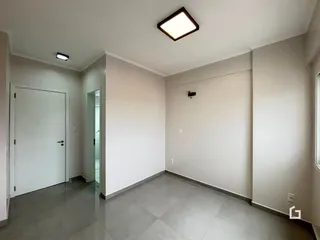 Hall de entrada com paredes brancas e piso de cerâmica.