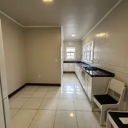 Corredor interno com paredes brancas e piso de cerâmica.