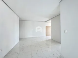Vista de um corredor amplo com piso de mármore claro em uma residência.