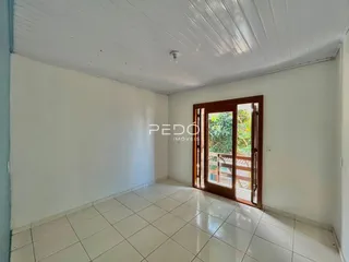 Interior de um cômodo com piso de cerâmica e porta de madeira.