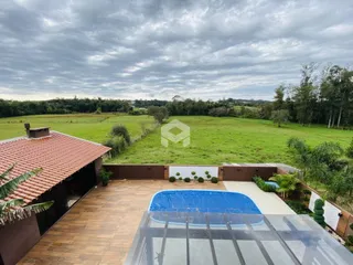 Vista externa de uma propriedade com piscina e jardim.