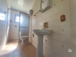 Foto de um banheiro com azulejos brancos e um lavatório de pedestal.