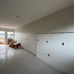 Ambiente interno com piso de cerâmica e armários brancos.
