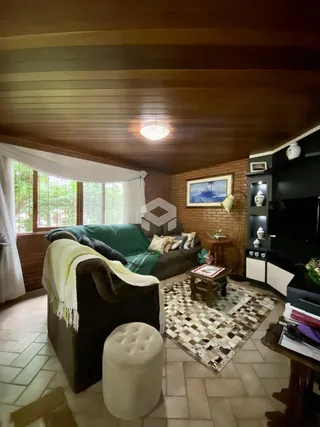 Sala de estar com sofá e piso de cerâmica em uma residência.