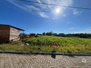 Vista externa de um terreno gramado com uma estrutura de madeira.