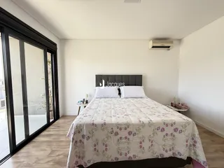 Quarto com cama e porta de vidro de grande porte.