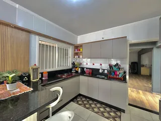 Cozinha moderna com armários cinzas e bancadas escuras.
