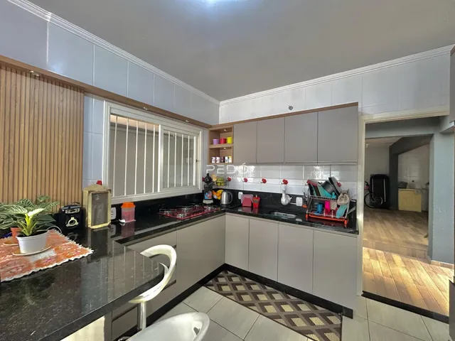 Cozinha moderna com armários cinzas e bancadas escuras.